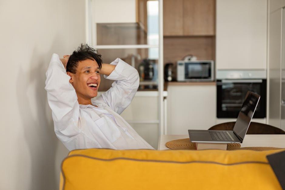 Person smiling and working on a laptop in a comfortable, modern home office